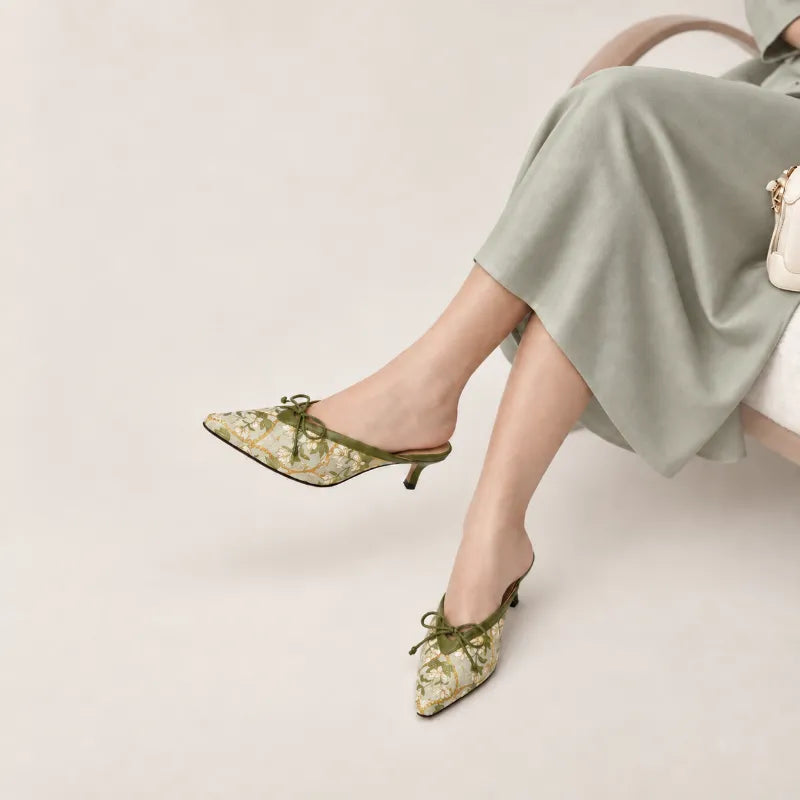 Woman wearing luxury Dayun Brocade Verdant Floral kitten heel mules with an elegant modern outfit.