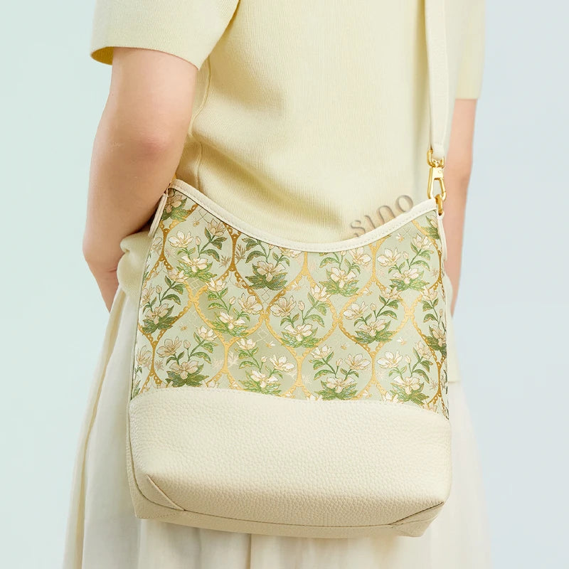 Back view of a model wearing the Chinoiserie Dayun Brocade Verdant Floral leather shoulder bag.