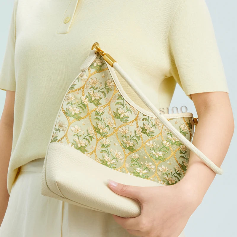 Model carrying the Dayun Brocade Verdant Floral leather shoulder bag styled with a soft pastel outfit.