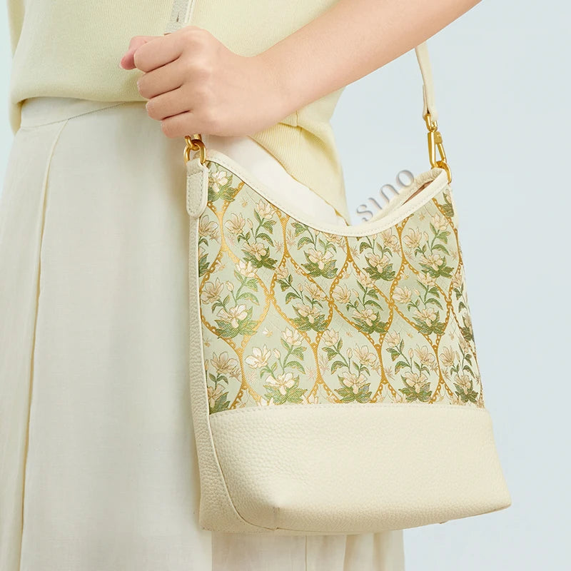 Side view of the Luxury Dayun Brocade Verdant Floral leather shoulder bag worn by a model.