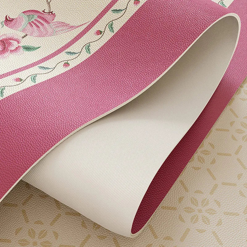 Flexible coral pink round leather table mat with anti-slip backing.