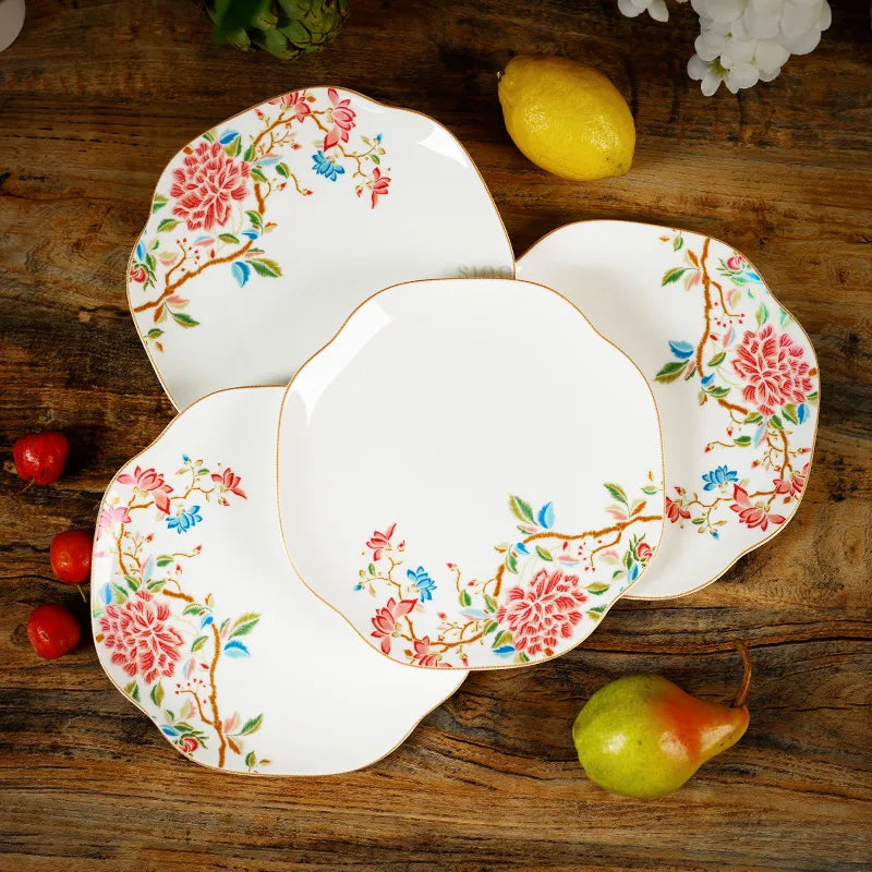 Four chinoiserie plates arranged with fresh pears on table, top-down setting.