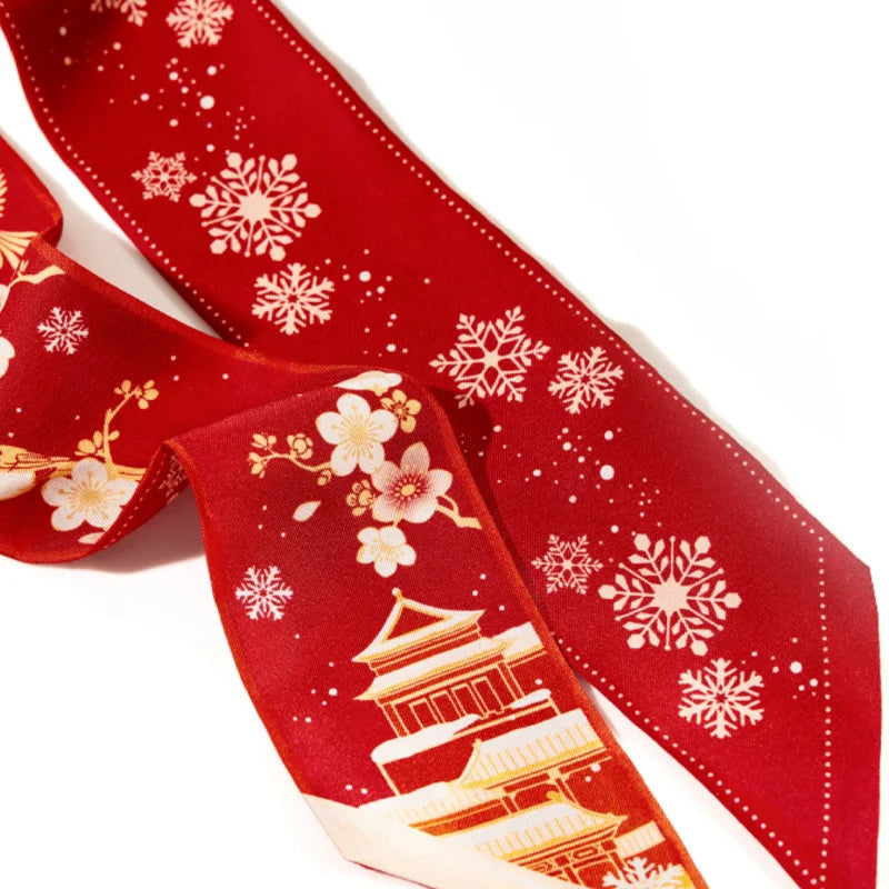 Close-up of the red Forbidden City Mulberry Silk Twilly featuring snowflakes, plum blossoms and traditional palace architecture.