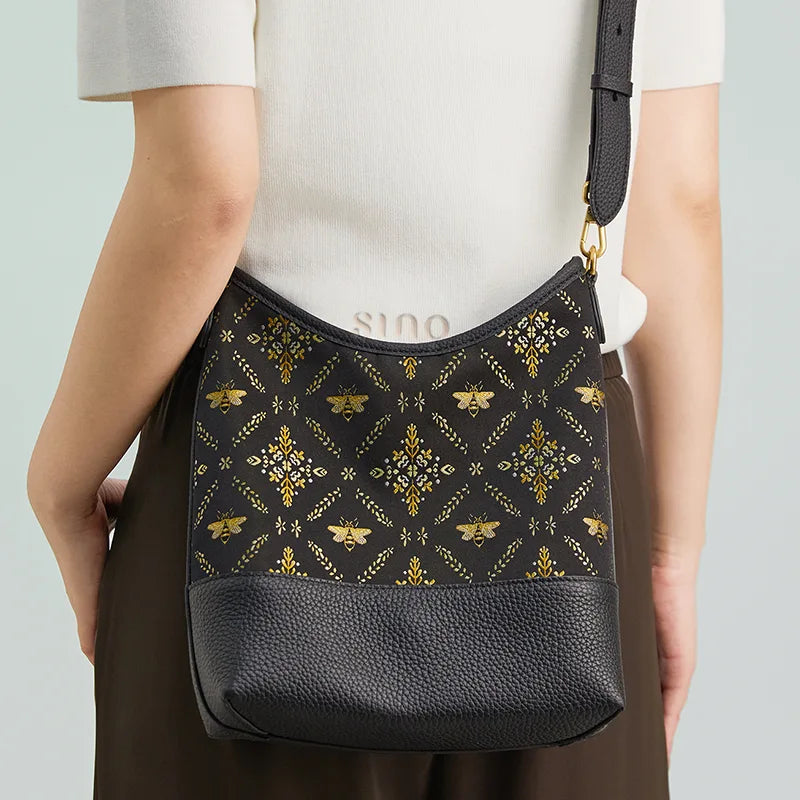 Model wearing the black Gilded Jade Shu Brocade leather shoulder bag with a modern neutral outfit.