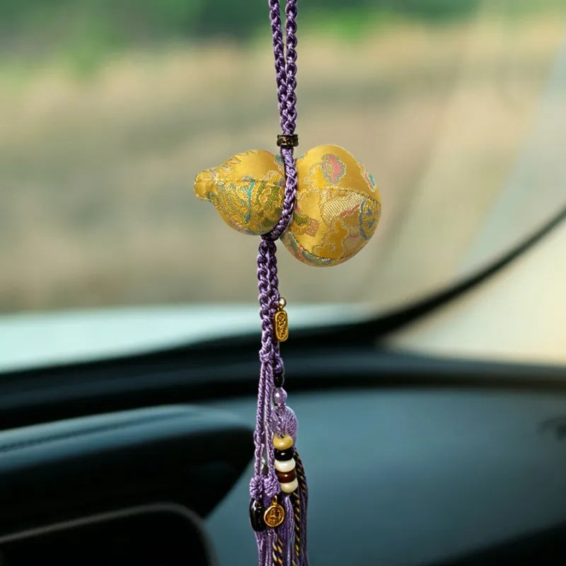 Golden Nanjing Yunjin brocade Hulu long tassel bag charm displayed inside a car with a braided purple cord and decorative hanging tassel.