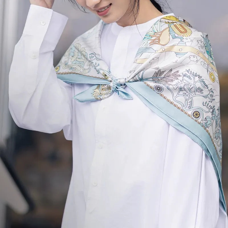 Luxury Nanjing Brocade Grand View Garden mulberry silk large square scarf worn as a shoulder wrap and tied at the front, highlighting the lightweight silk texture and refined ornamental pattern.