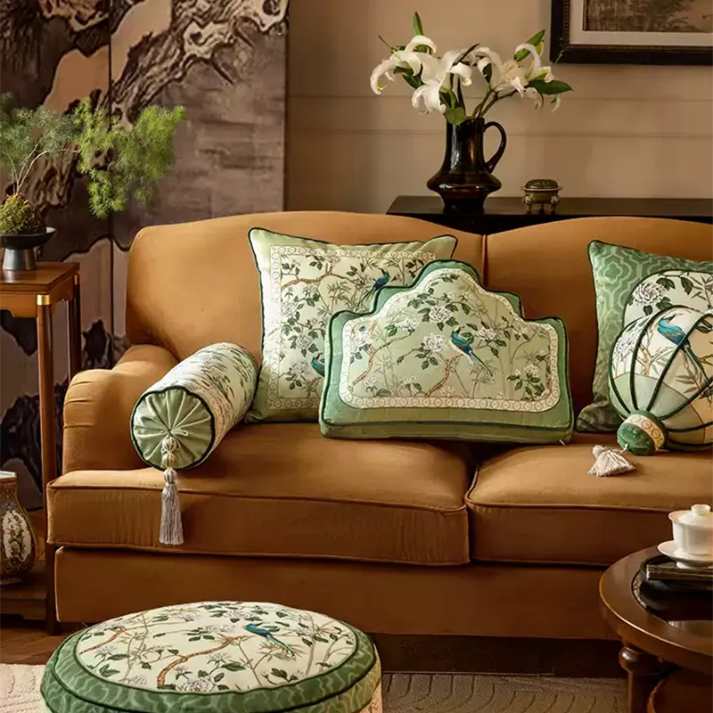 Armrest, backrest, and lantern-shaped luxury chinoiserie jade green decorative throw pillows lined up on a sofa.