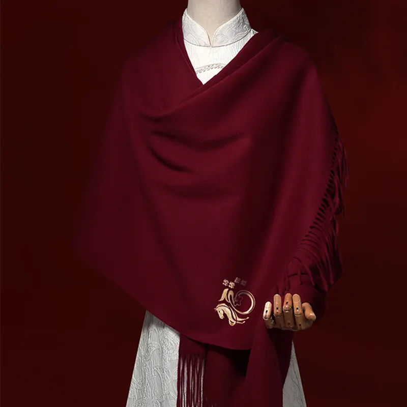 Horse & persimmon embroidered cashmere scarf draped on mannequin – versatile luxury accessory.
