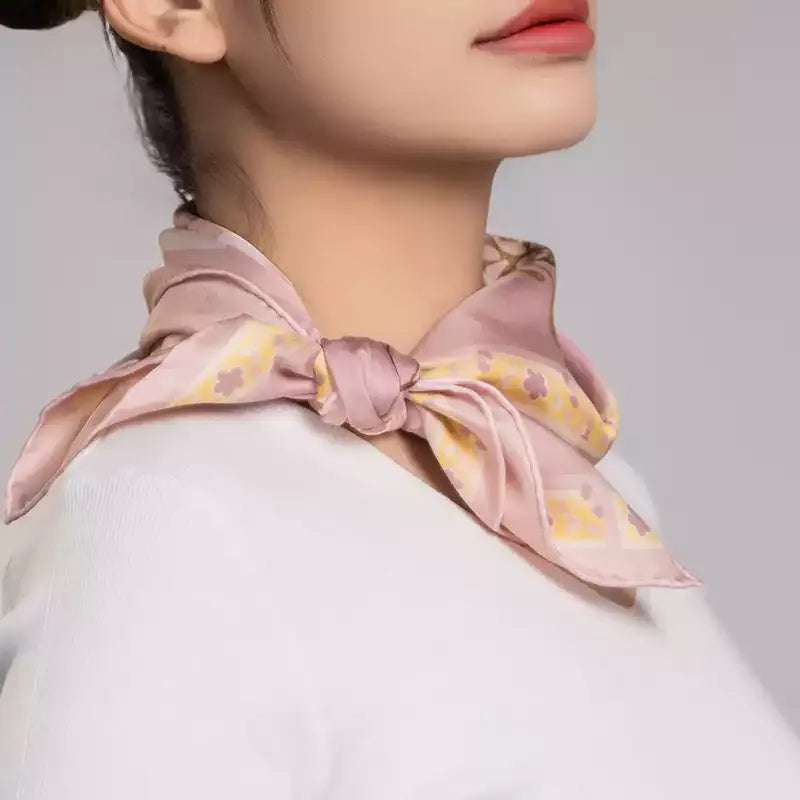 Model wearing a Luxury Nanjing Brocade Garden Rabbit mulberry silk square scarf tied in a soft pink neck knot.