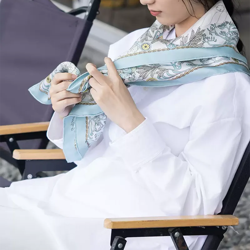 Close-up of the Luxury Nanjing Brocade Grand View Garden mulberry silk large square scarf styled around the shoulders, showing the soft drape, pale blue border, and elegant Chinese-inspired print.