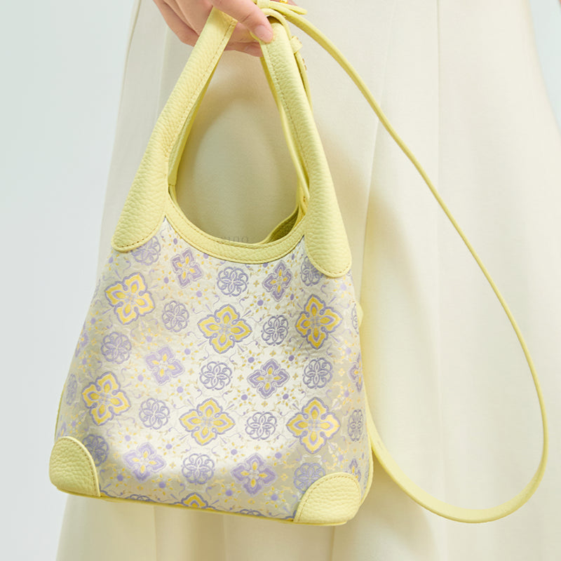 Close-up model view of the Luxury Shu Brocade Persimmon Calyx Motif Basket Tote Bag, showing the persimmon calyx motif, leather handles, and long strap.