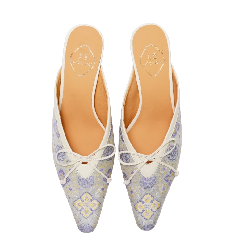 Transparent top view of Luxury Shu Brocade Ruyi Fortune kitten heel mules for women featuring ivory brocade fabric, lavender and gold Chinese motifs, pointed toes, bow details, and elegant Oriental craftsmanship.