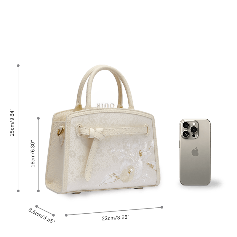 Size reference image of the Luxury Shuanglin Silk Orchid Butterfly Embroidered Leather Top Handle Bag beside a smartphone.