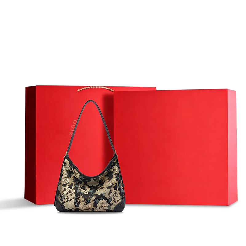 Luxury Song Brocade Black Gold Qilin Peony Leather Crossbody Bag displayed with a red gift box, suitable for gifting.