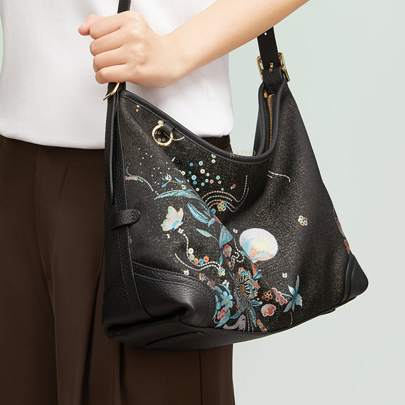 Angled model view of the Luxury Song Brocade Blooming Flowers Leather Crossbody Bag, showing the blooming flowers Song brocade pattern and elegant drape.