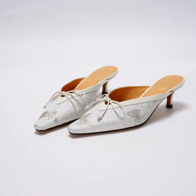 Side view of Luxury Song Brocade Butterfly Reverie kitten heel mules with pointed toe, delicate bow detail, and elegant low heel.