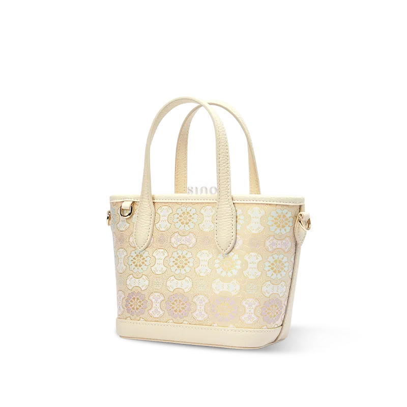 Side view of luxury Song brocade ivory Dingsheng motif top-handle tote bag on white background.