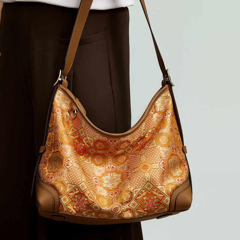 Close-up model view of the Luxury Song Brocade Orange Peony Motif Leather Crossbody Bag, featuring the detailed orange peony motif and brown leather accents.