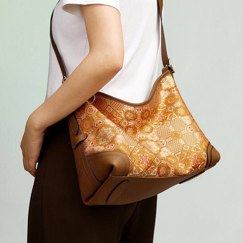 Side model view of the Luxury Song Brocade Orange Peony Motif Leather Crossbody Bag, showing the orange peony motif brocade and brown leather body.