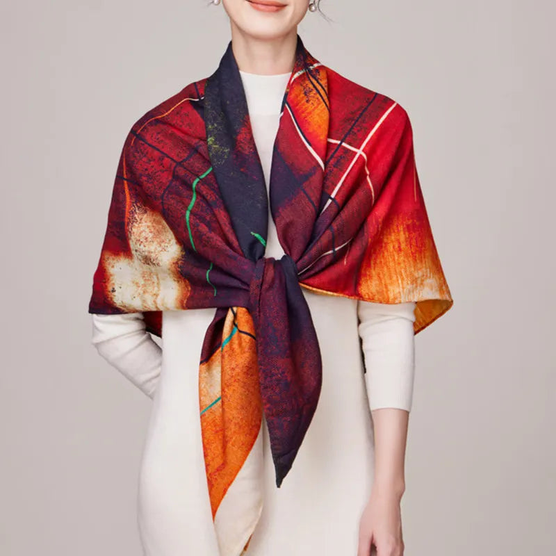 Red side of luxury square scarf with Chinese design knotted at model chest.