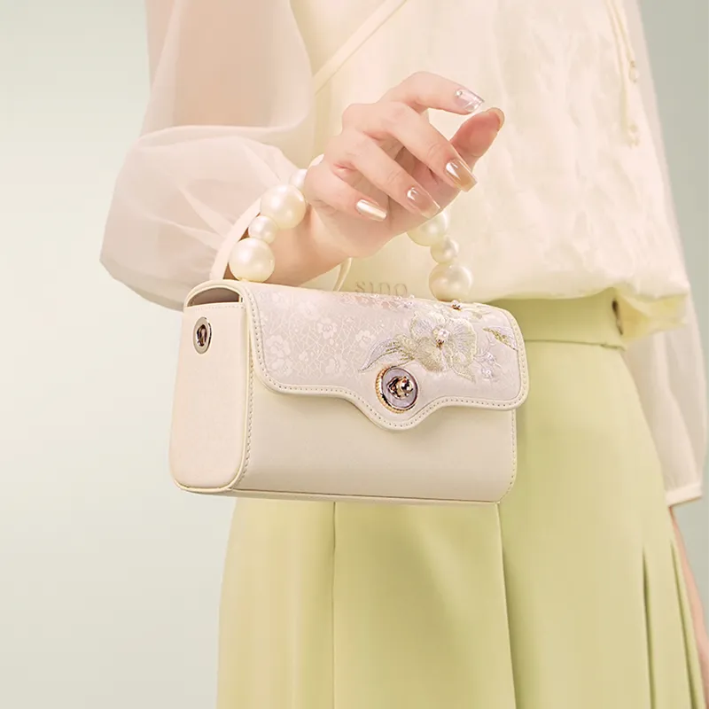 Model carrying Luxury Orchid Butterfly Design Embroidered Silk bag on arm.