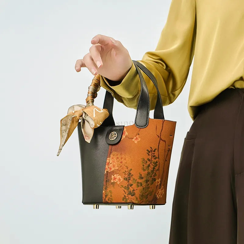 Model carrying plum blossom bag in arm crook position.
