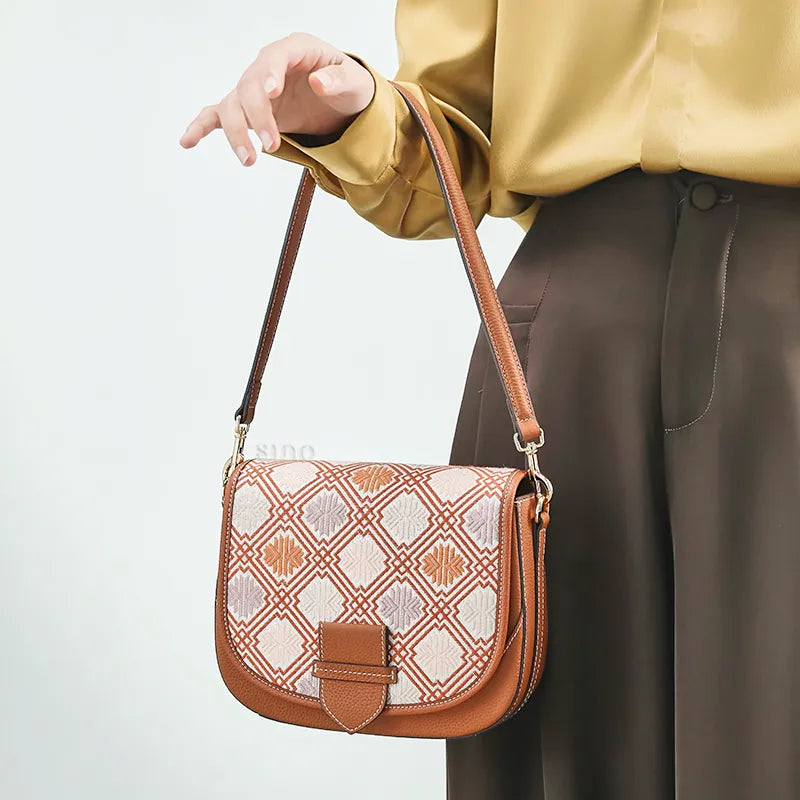 Model carrying messenger bag with single hand.