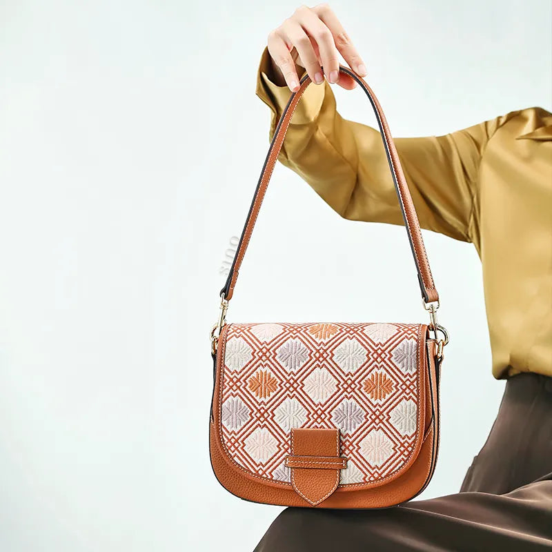 Seated model holding brocade bag on lap.
