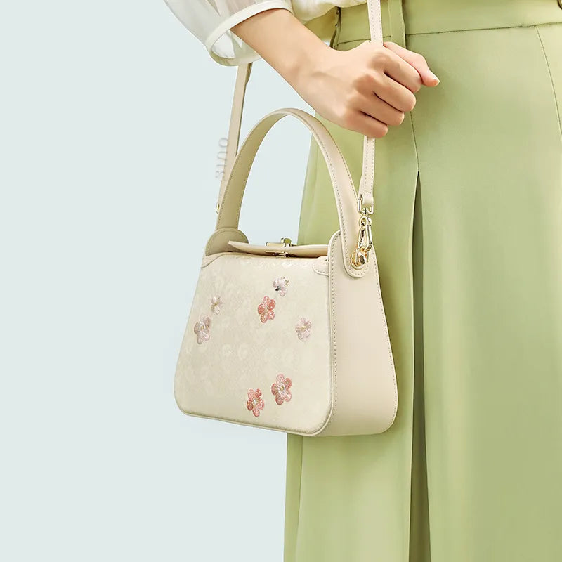 Model wearing plum blossom bag on single shoulder.
