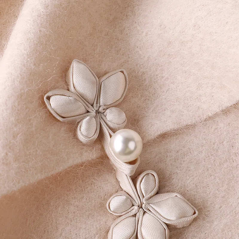 Satin-finished button closure for secure wear on embroidered scarf.