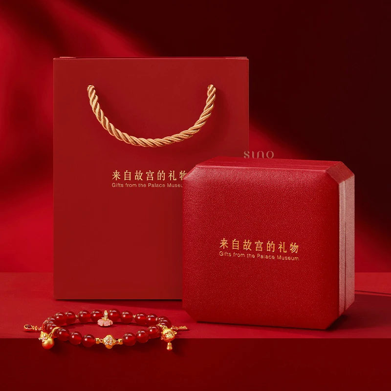 Red agate beaded bracelet presented with a red Palace Museum gift box and matching gift bag, ready for Chinese New Year gifting.