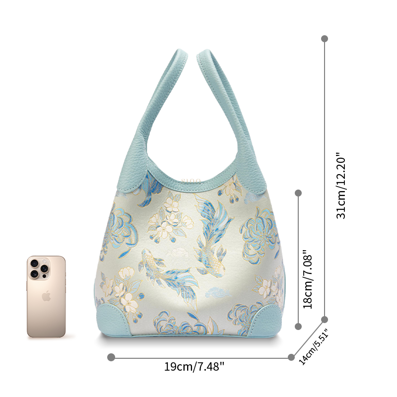 Size reference image of the Luxury Shu Brocade Golden Fish & Flower Leather Basket Tote Bag, shown with a phone for scale and daily capacity.