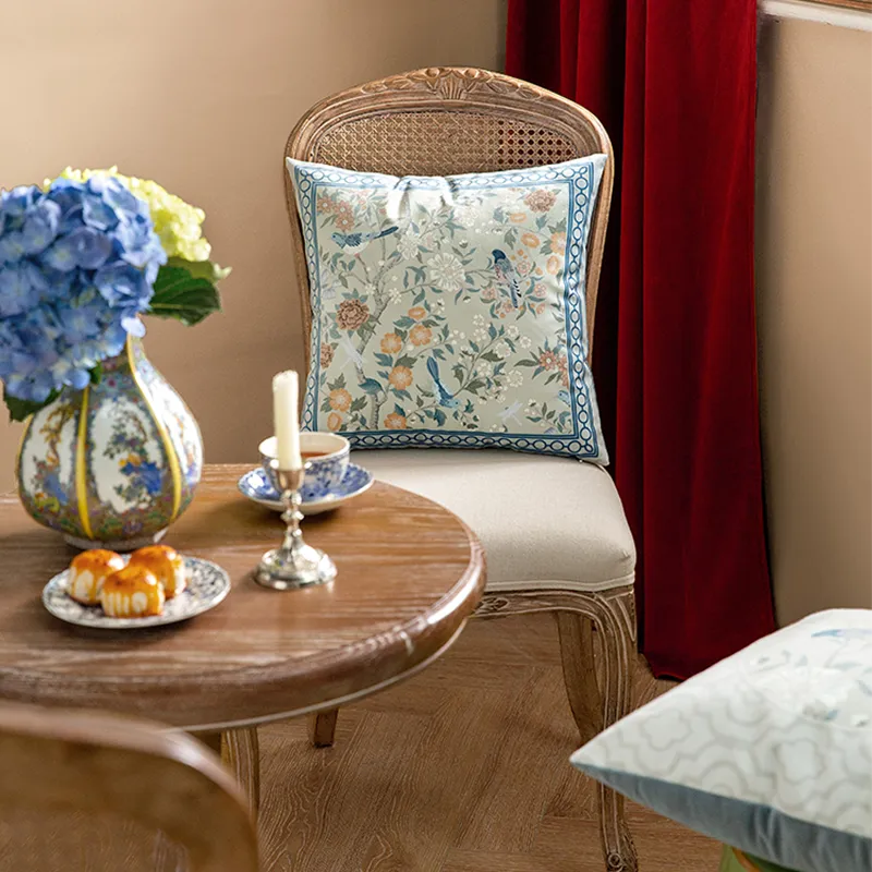 Chinoiserie luxury floral birds pillow on chair, front view.