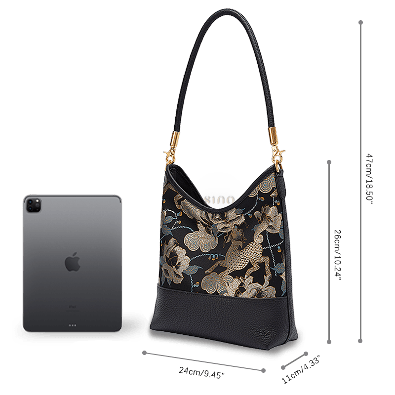 Size and capacity comparison of the Black Gold Qilin Peony leather shoulder bag beside a tablet.
