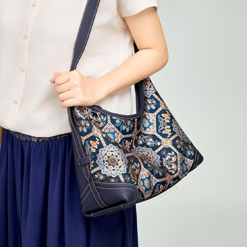 Luxury Song Brocade Blue Baoxiang Floral Crossbody Bag shown on model, side angle displaying handle and crossbody strap.