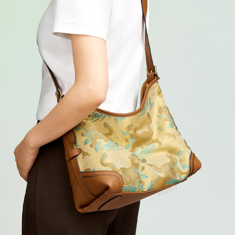Close-up model view of the Song Brocade Brown Tiger Leather Crossbody Bag, showing the brocade texture, brown tiger pattern, and leather details.