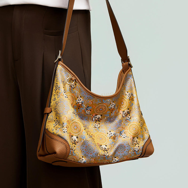 Close-up model view of the Chang’an Court Dance Leather Crossbody Bag, highlighting the panda brocade motif, curved shape, and leather details.