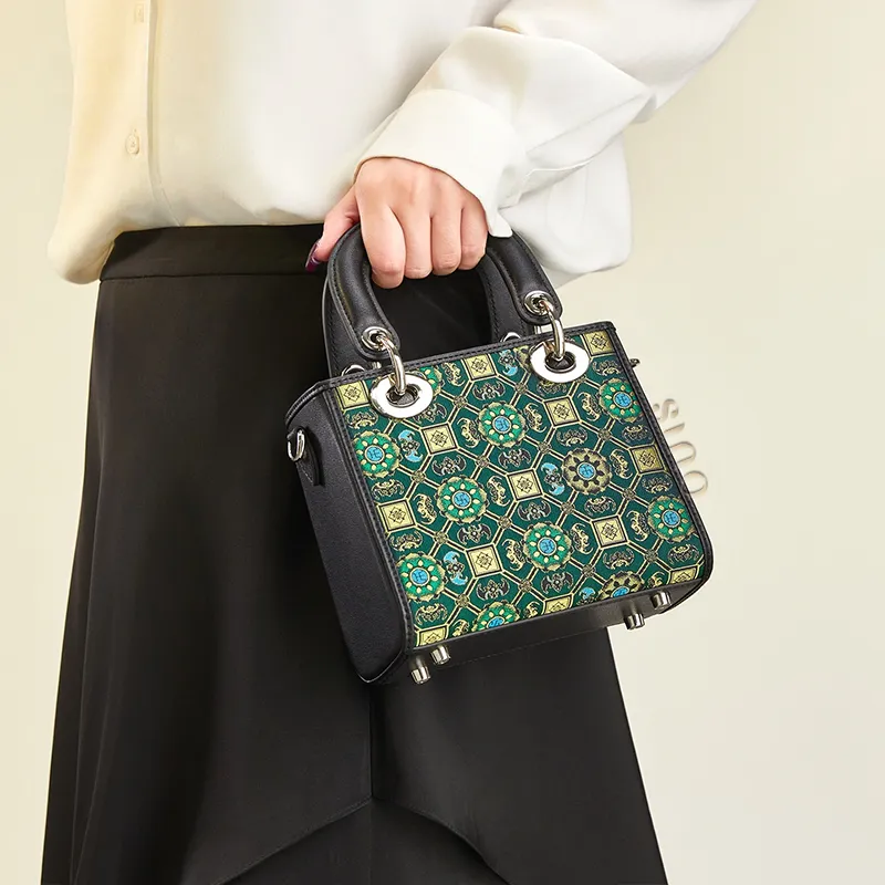 Model carrying the Song Brocade Lotus and Auspicious motif mini handbag in a refined outfit.