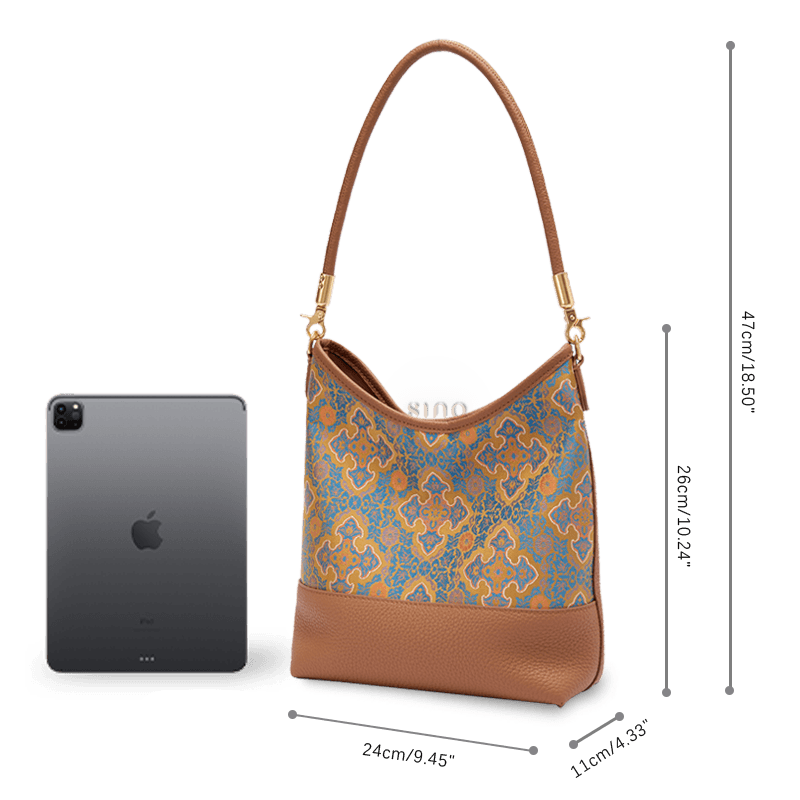 Size and capacity comparison of the Song Brocade Ruyi Motif leather shoulder bag shown beside a tablet.