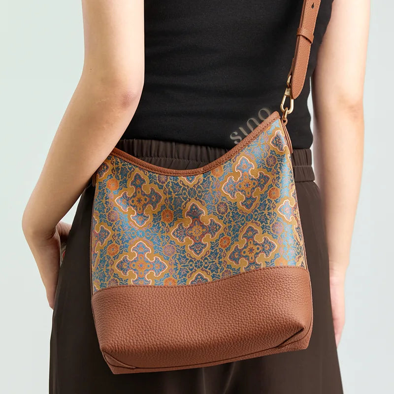 Back view of a model wearing the Chinoiserie Ruyi Motif leather shoulder bag with an adjustable brown strap.