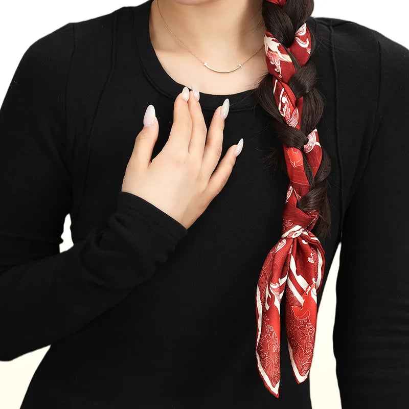 Woman styling the Steed Across the Tides Mulberry Silk Square Scarf as an elegant red hair scarf woven through a braid.