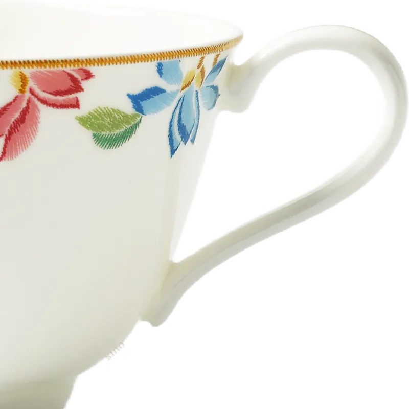 Cup button handle and right-side embroidered floral detail.
