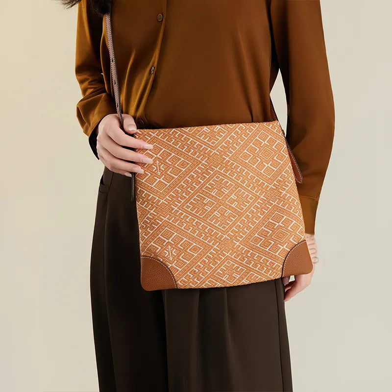 Model standing front view wearing the Zhuang Brocade Chrysanthemum Meander Motif Messenger Crossbody Bag crossbody in front.