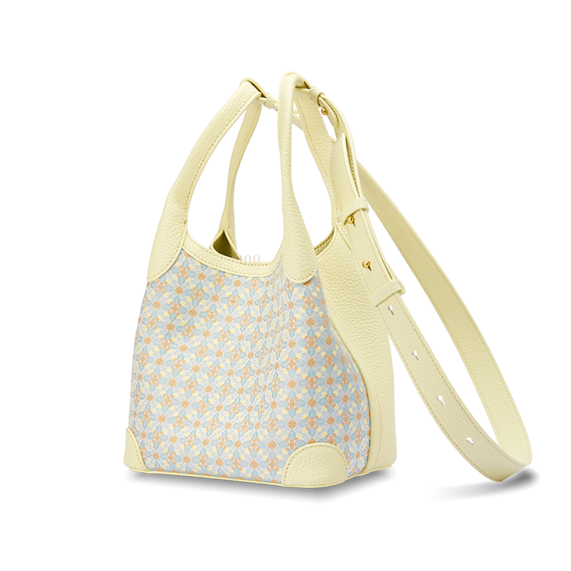 Angled view of the Luxury Zhuang Brocade Osmanthus Motif Leather Basket Tote Bag with adjustable long strap, showing the structured silhouette and pale yellow leather trim.