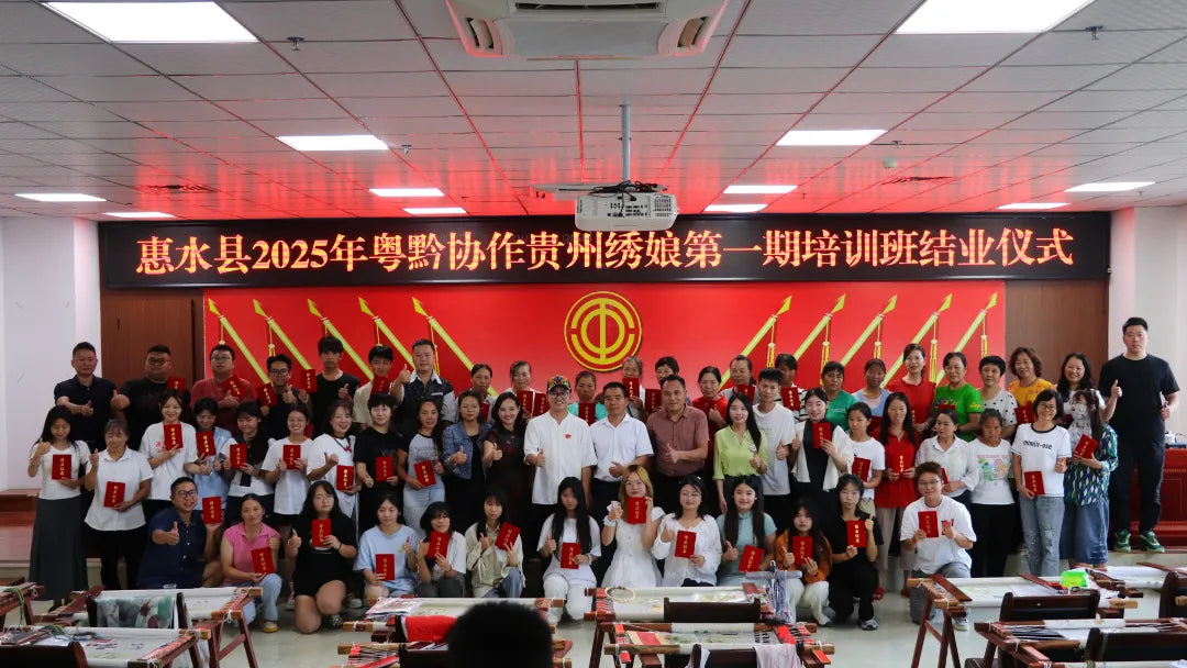 Group of women trainees holding certificates at 2025 first phase Cantonese Embroidery training graduation ceremony in Guizhou.