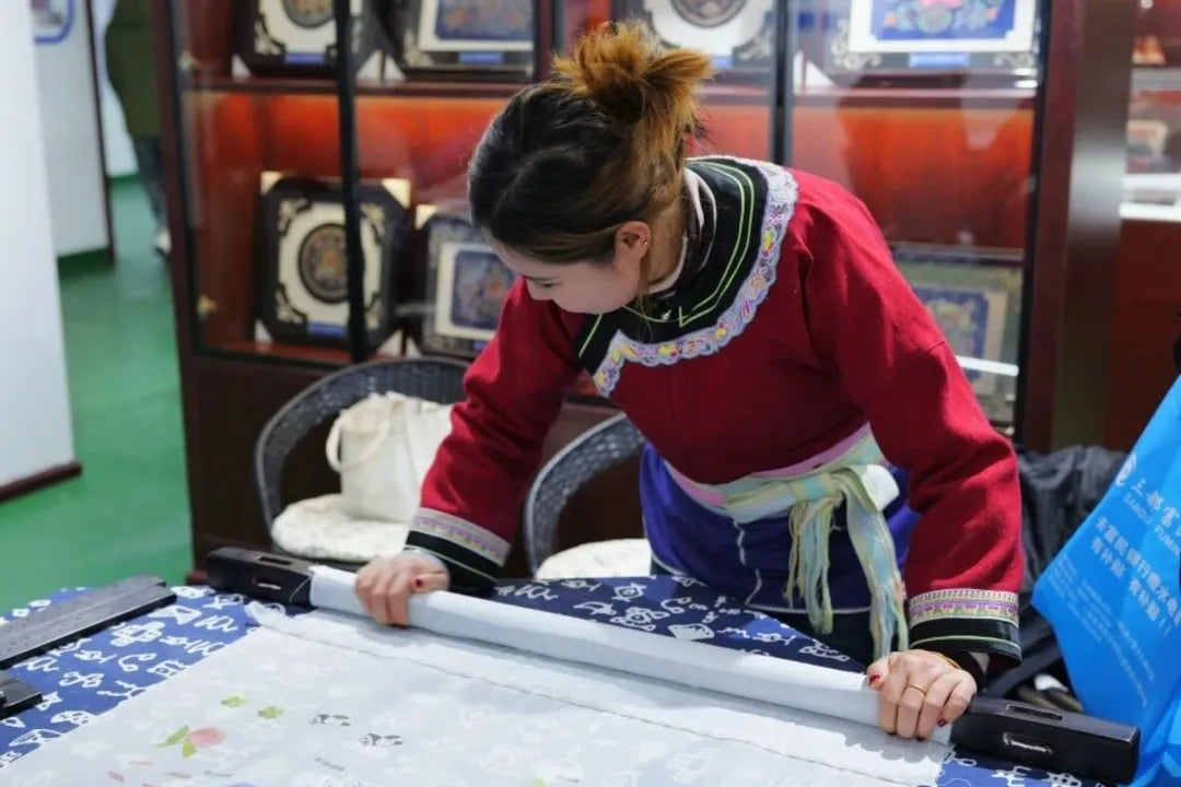 Female artisan working on embroidery with a roller hoop, celebrating women who shape culture this Women’s Day.