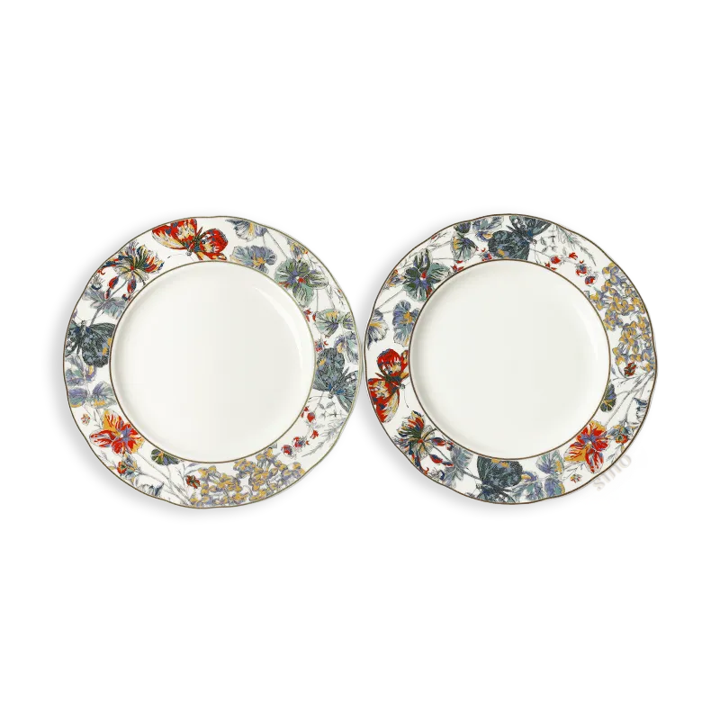 Two Chinoiserie bone china scalloped dinner plates with butterfly and floral design, placed side by side.