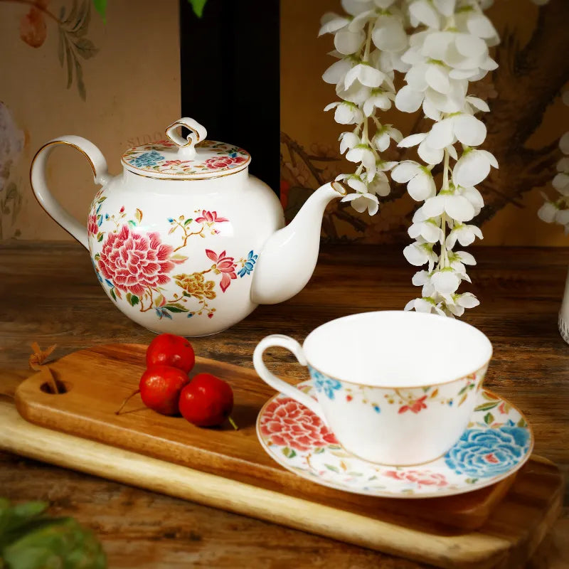 3-piece floral bone china tea set: teapot, cup and saucer on white background.