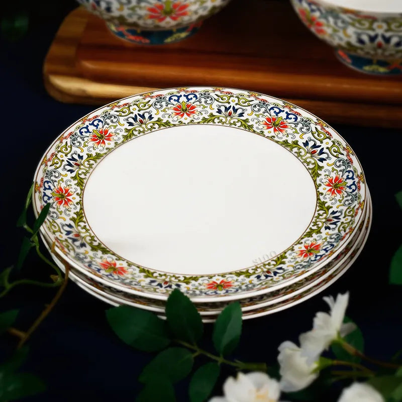 Three stacked plates at 45° angle with floral accents showing enamel border.