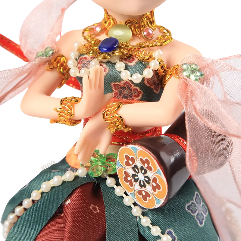Lower body of 9-inch Dunhuang doll showing red floral skirt and green decorative panels.
